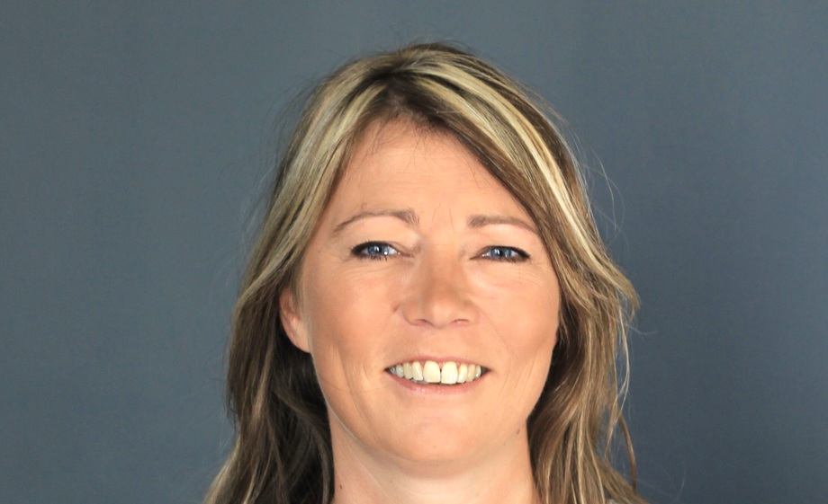 Nadine Meyer, Heilpraktikerin, vor blau- grauem Hintergrund- Kontakt und Terminbuchung